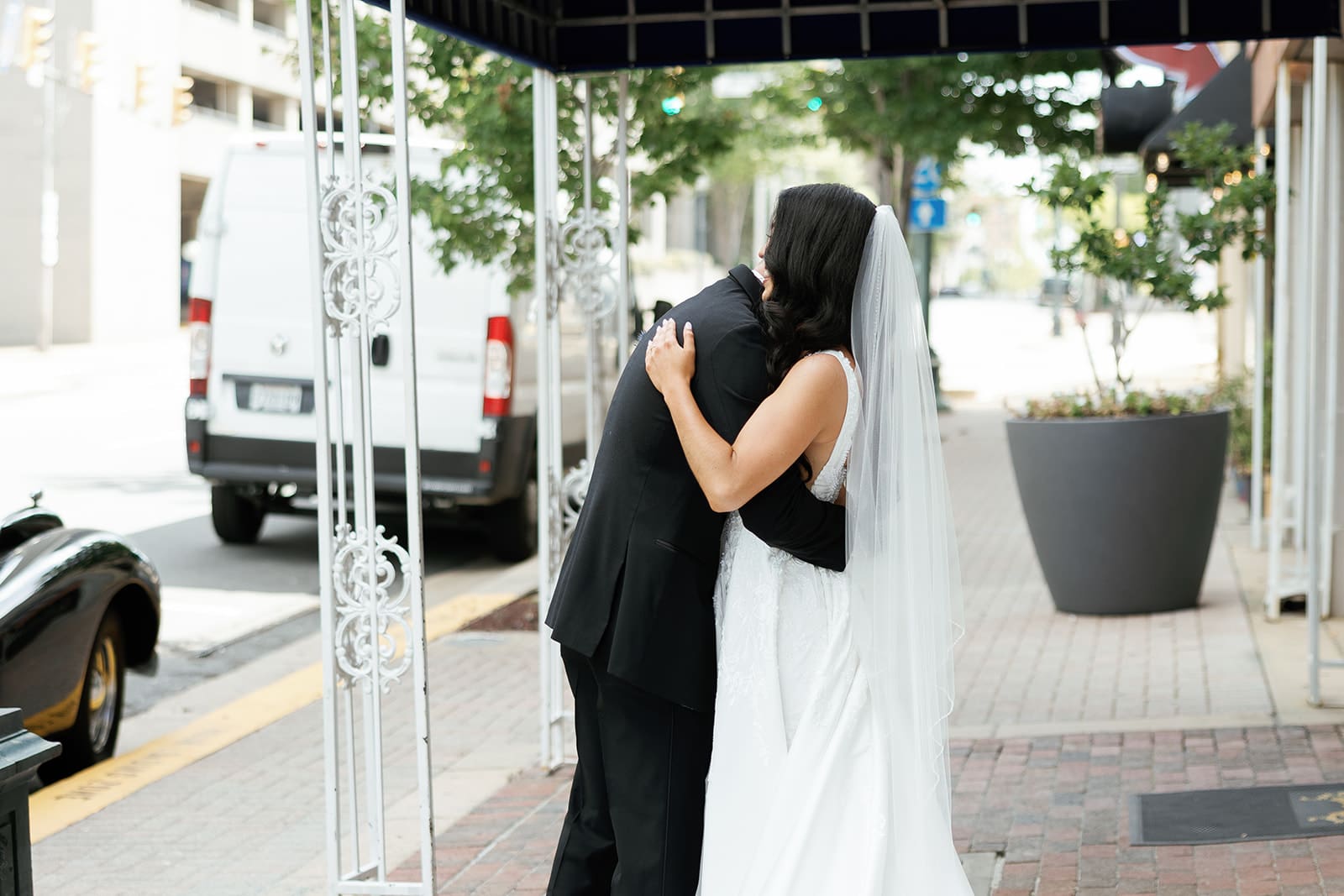 Bride and groom posing in downtown Dallas with videographer capturing movement Bride and groom posing in downtown Dallas with videographer capturing movement