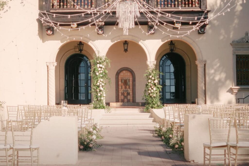 Elegant outdoor wedding ceremony setup with floral arch, aisle seating, and venue space prepared for wedding toasts